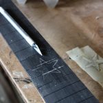 A scalpel was used to score all the way round- rubbing in light coloured dust shows up the shape