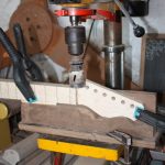 A hole cutter is used to make the curve from the top of the headstock to the top of the fretboard